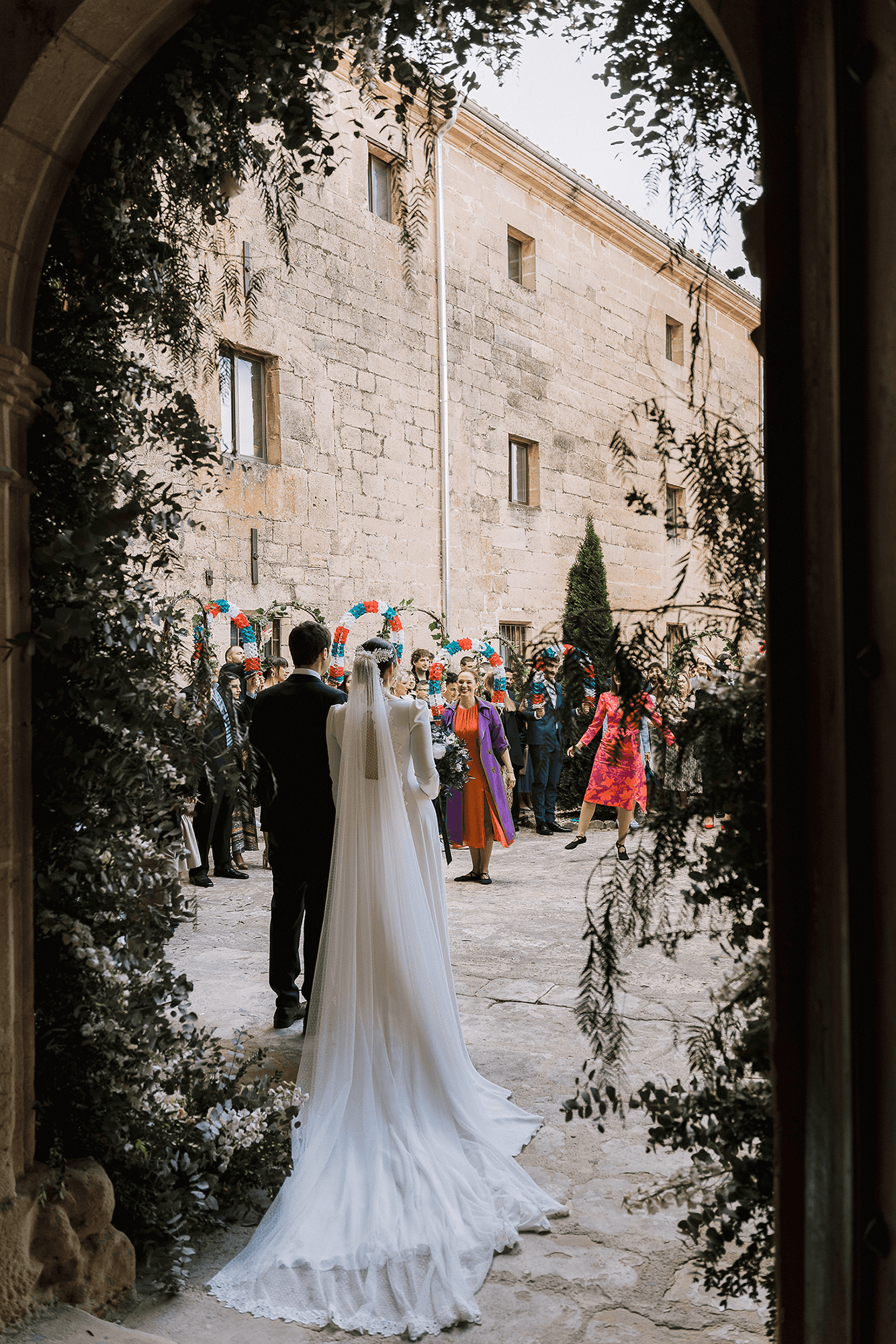 Novios en un pórtico con ramas de eucalipto