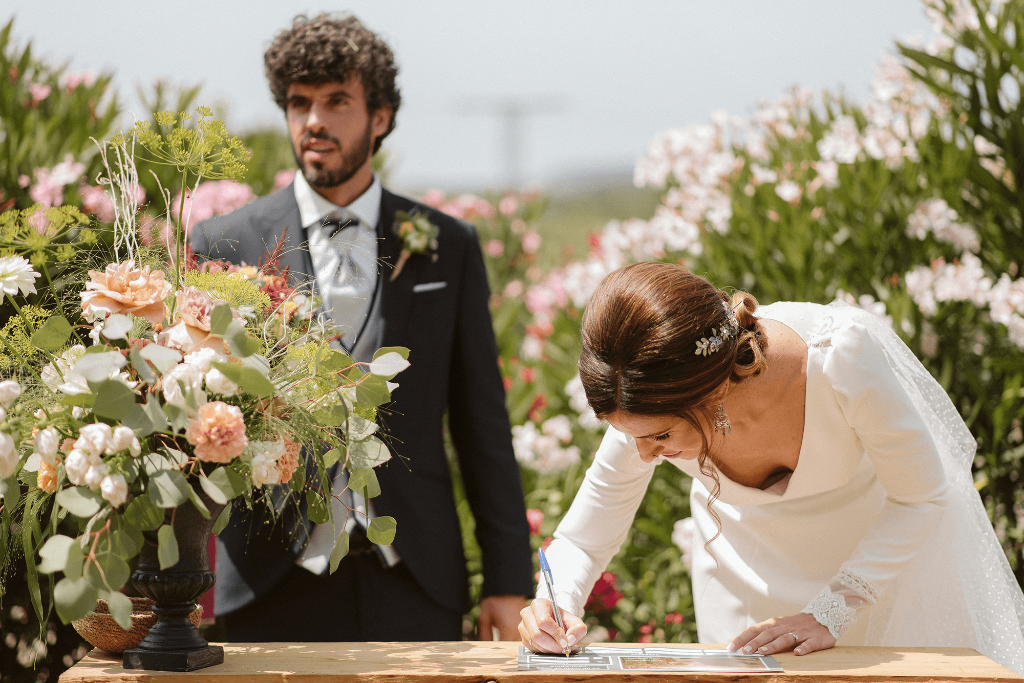 Novios firmando con ramo de flores